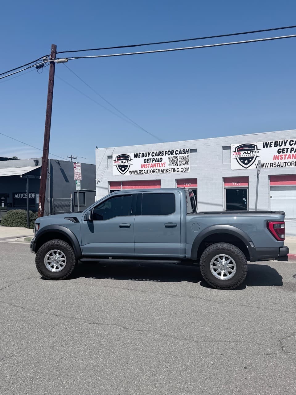 Gray Ford F-150 Raptor in front of the dealership